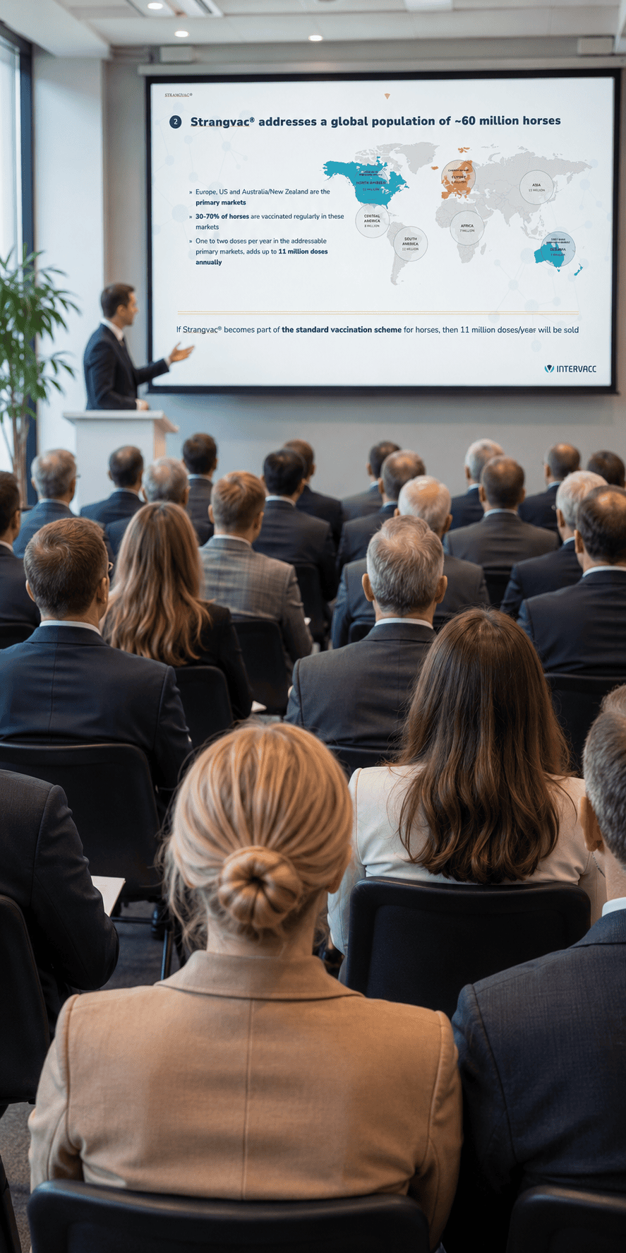Articles of Association Audience at a meeting, a man presenting Intervacc via projector